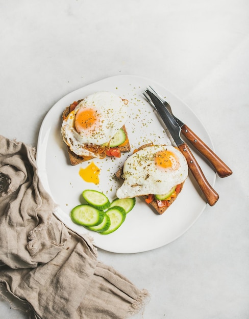 Frühstückstoast mit Spiegeleigemüse auf weißer Platte