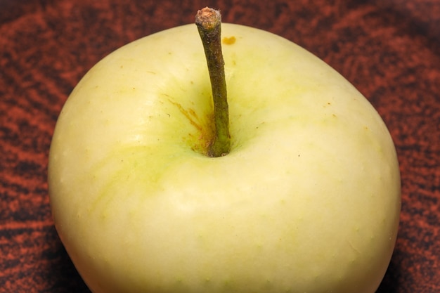 Fruitimagem maçã doce madura branca em um prato de argila marrom close-up macro fotografia