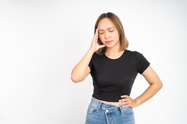 Frustrada jovem asiática segurando a cabeça com dor de cabeça