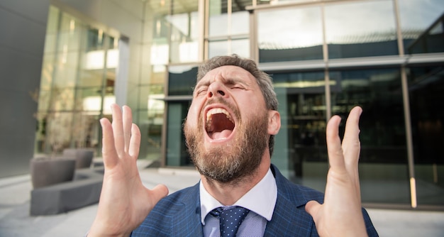 Frustrado gritando hombre de negocios barbudo en bancarrota de traje formal