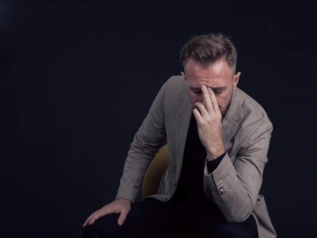 Frustrado hombre elegante de mediana edad Cierre la cara de un hombre de negocios estresado que lleva un traje elegante con los ojos cerrados. Hombre de negocios del Medio Oriente con exceso de trabajo con terrible migraña. foto de alta calidad