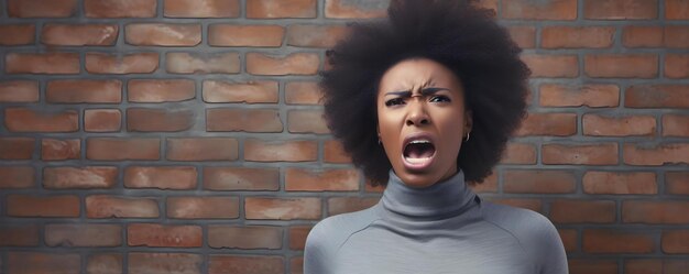 Frustrierte afrikanische Frau in grauem Sweatshirt gegen Ziegelsteinwand hintergrund, die Wut ausdrückt Konzept Wut Frustration Porträtfotografie Ziegelsteenwand Hintergrund afrikanische Frauen