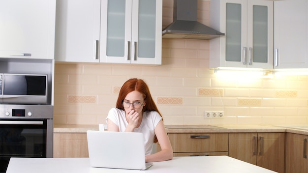 Frustrierte Frau, die von zu Hause an ihrem Computer arbeitet