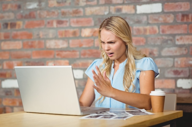 Foto frustrierte geschäftsfrau, die vor laptop sitzt