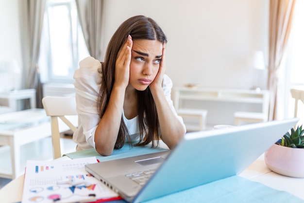 Frustrierte junge Frau, die von zu Hause aus arbeitet