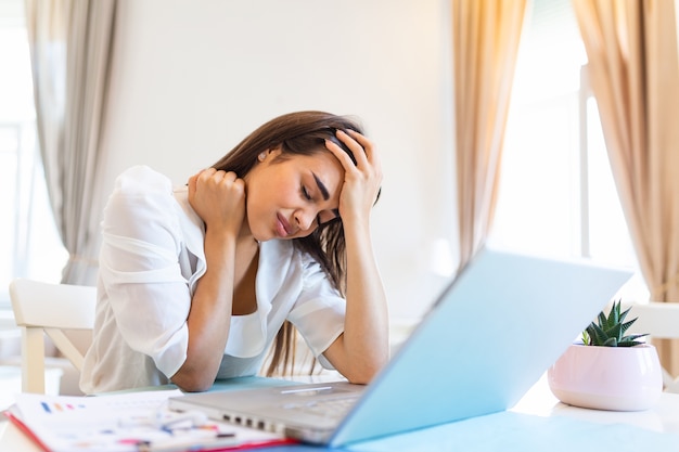 Frustrierte junge Frau, die von zu Hause aus arbeitet