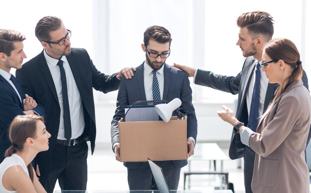 Frustrierter Mitarbeiter mit persönlichen Dingen, die im Büro stehendas Konzept der Entlassung