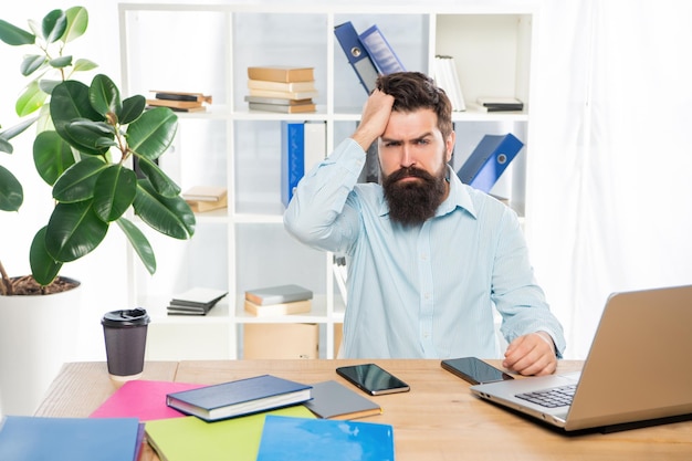 Frustrierter, professioneller Typ, der am Schreibtisch arbeitet, Frustration