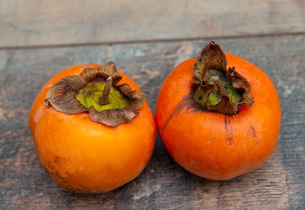 Foto fruta de caqui sobre una superficie de madera vieja,