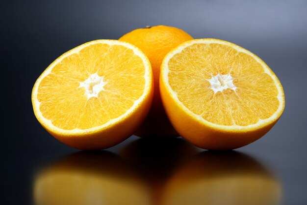 Fruta cítrica en rodajas de naranja en un espacio oscuro