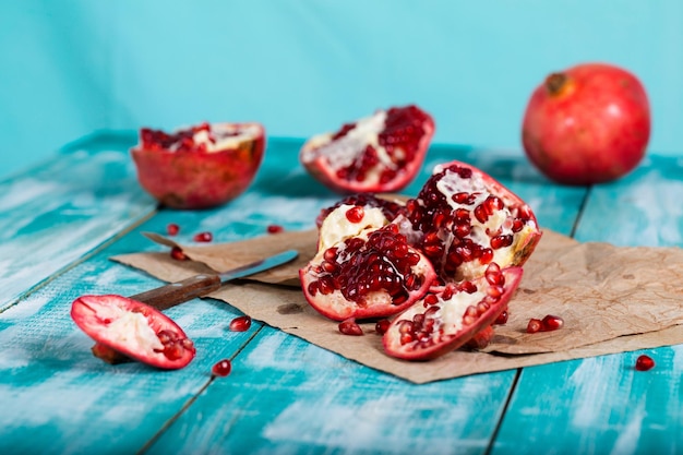 Fruta da romã em uma superfície de madeira ciano. Fechar-se