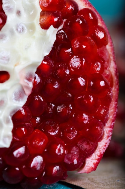 Fruta da romã em uma superfície de madeira ciano. Fechar-se