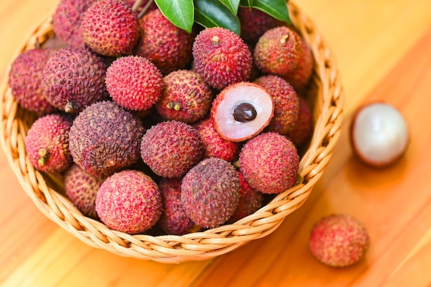 Fruta de lichia na cesta com folha verde e fundo de madeira lichia madura fresca descascada da árvore de lichia em frutas tropicais Tailândia no verão