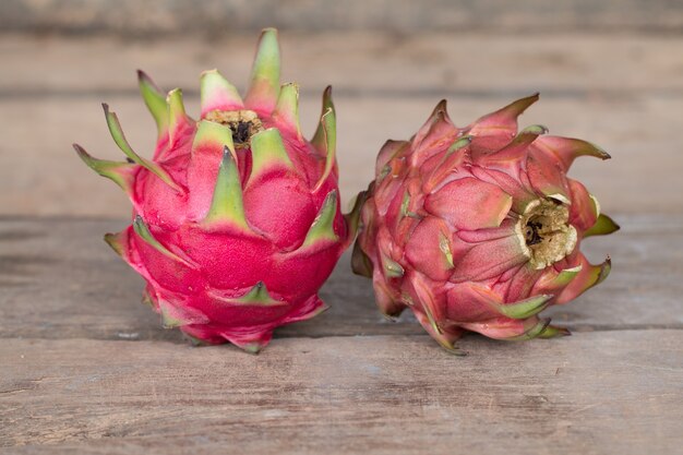 Fruta del dragón rojo o fruta tropical en el fondo de escritorio de madera