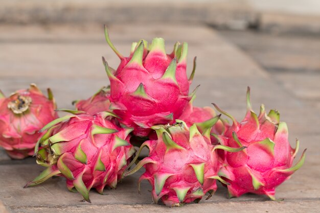 Fruta del dragón rojo o fruta tropical en el fondo de escritorio de madera