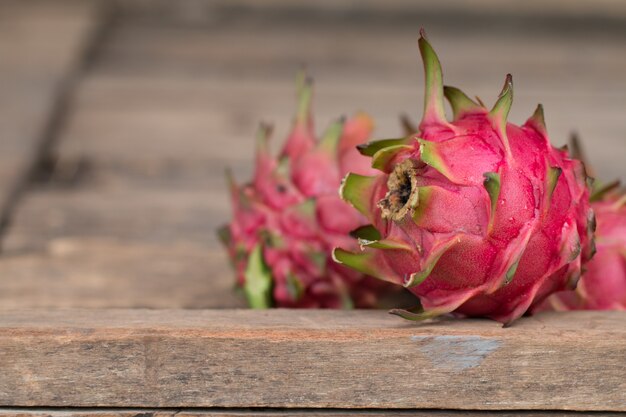 Fruta del dragón rojo o frutas tropicales sobre fondo de escritorio de madera