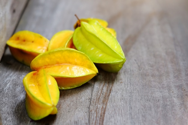 Fruta estrella amarilla madura o manzana estrella, Carambola sobre piso de madera