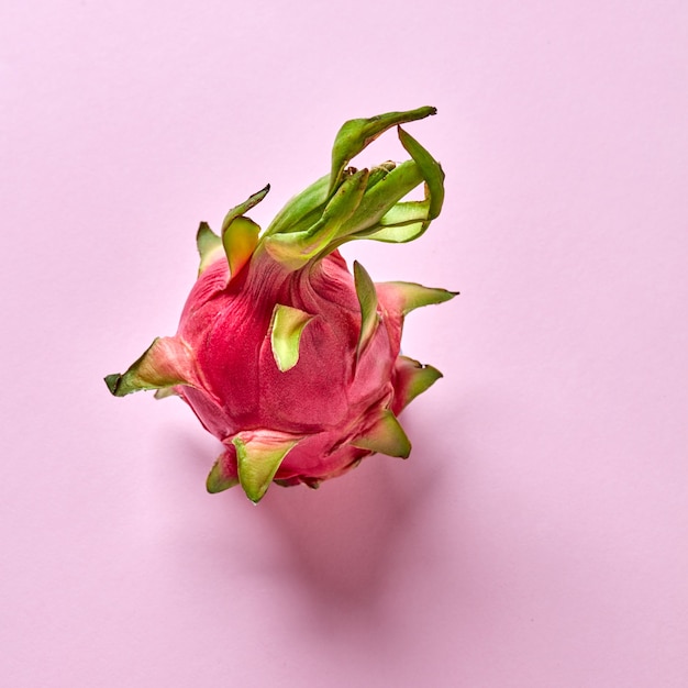 Fruta exótica orgânica natural madura - fruta do dragão em um fundo rosa, lugar para texto. Vista do topo. Conceito vegano saudável.