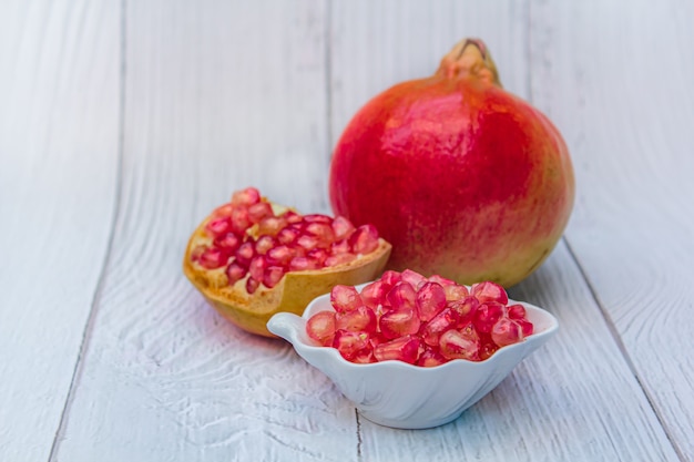 Foto fruta fresca da romã no branco de madeira.