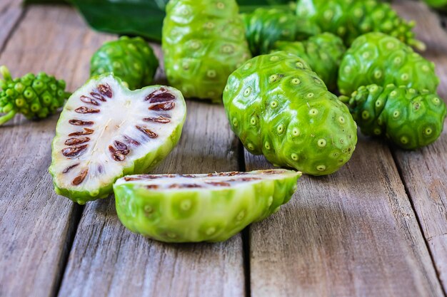 Fruta fresca de Noni em um fundo de madeira