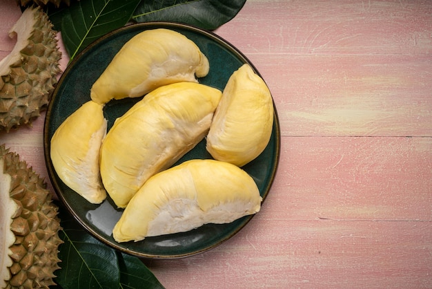 Fruta fresca de Durian en plato negro Fruta de Durian con cáscara el Rey de las frutas sobre fondo de madera