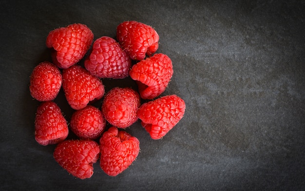 Fruta fresca de las frambuesas en la opinión superior del fondo oscuro