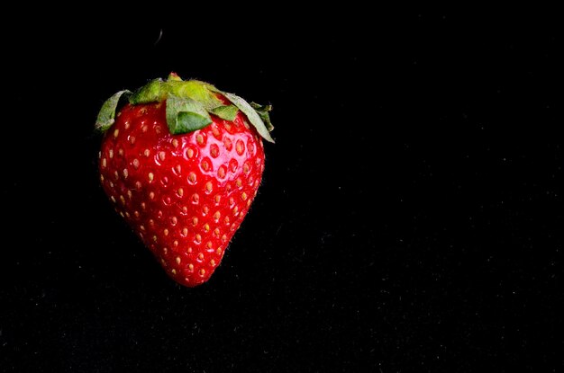 Fruta fresca de fresa madura sobre un fondo negro