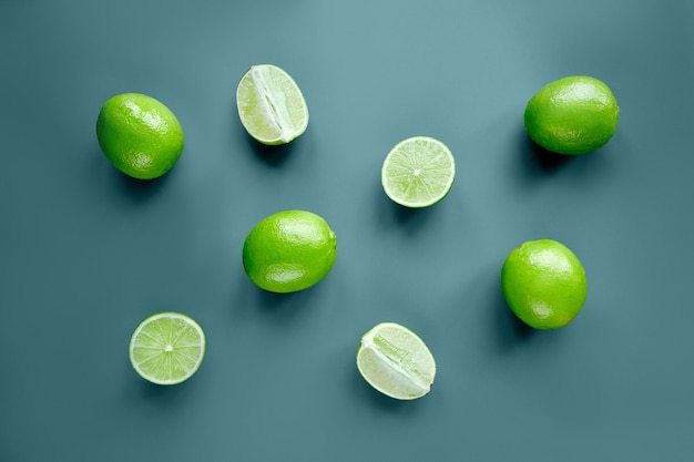 Fruta fresca de lima cruda sobre fondo verde claro Composición creativa sombras de luz solar Formato horizontal vista superior flatlay