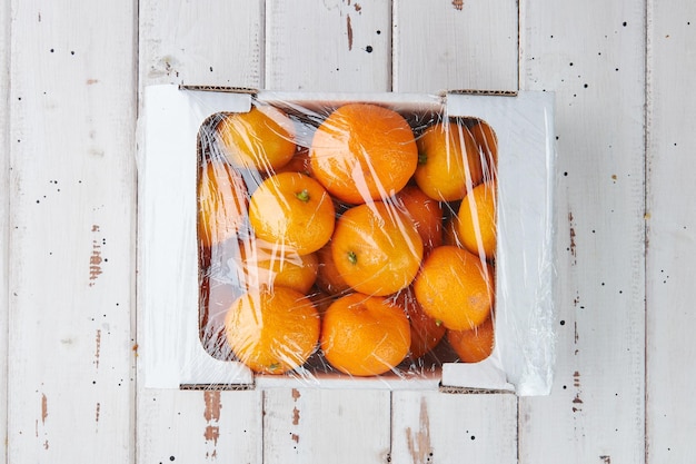 Fruta fresca de mandarinas o mandarinas con hojas sobre una mesa de madera