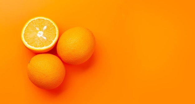 Fruta fresca de naranja madura sobre fondo naranja