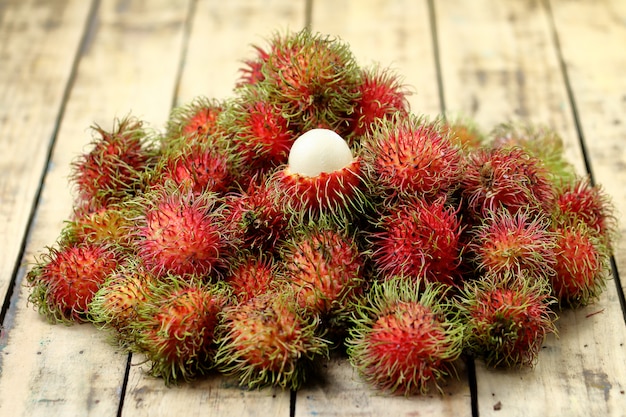 Fruta fresca de rambután sobre suelo de madera