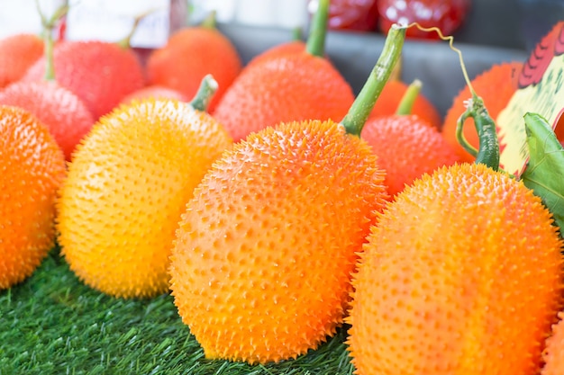 Fruta Gac, Baby Jackfruit, Spiny Bitter Gourd en caja de madera.