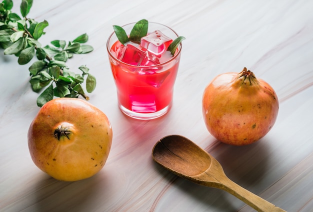 Fruta de granada y jugo de granada en mármol