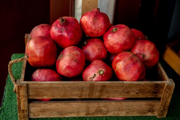 Fruta de granada saludable en caja de madera en el mercado