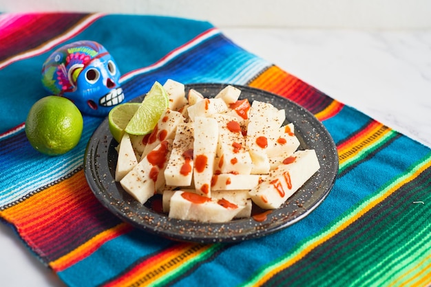 Foto fruta de jícama mexicana cortada con chile limón y chamoy