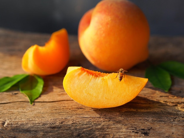 Fruta jugosa de melocotones con una abeja