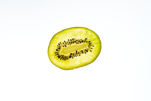 Fruta kiwi cortada en rodajas sobre fondo blanco.