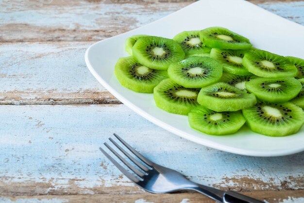 Fruta de kiwi fresca en una placa en una mesa de madera