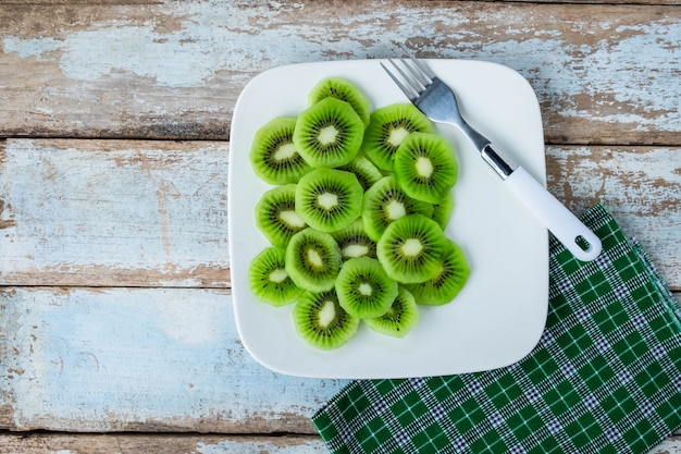 Foto fruta de kiwi fresca en una placa en una mesa de madera