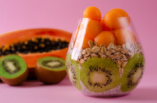 Fruta de kiwi, papaya y avena frescas para un desayuno saludable en púrpura