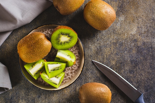 Fruta de kiwi recién madura en rodajas en un plato en la vista superior de la mesa