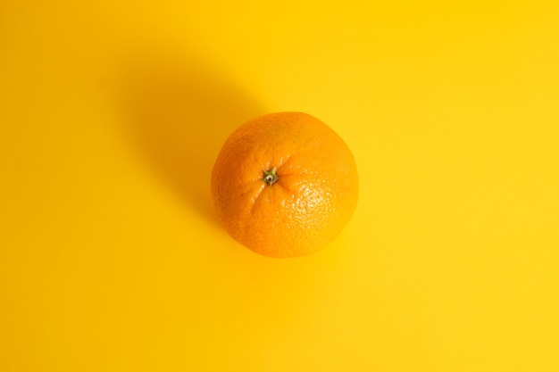 Fruta laranja amarela em uma mesa amarela