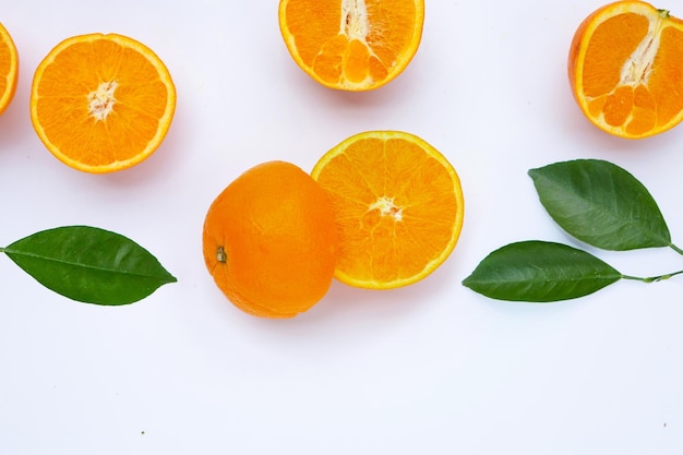 Fruta laranja com folhas verdes no fundo branco