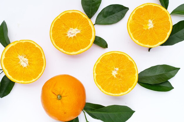 Fruta laranja com folhas verdes no fundo branco