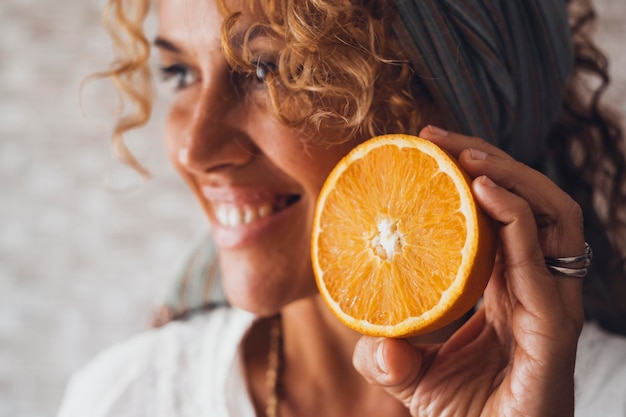 Foto fruta laranja e retrato de mulher bonita jovem adulta feliz sorrindo no fundo desfocado conceito de bem-estar e estilo de vida alimentar saudável vitamina c nutrição de saúde pessoas e frutas