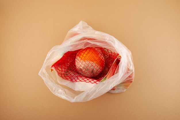 Fruta laranja estragada em saco plástico. Armazenamento inadequado de frutas cítricas Reduzir o desperdício de alimentos orgânicos