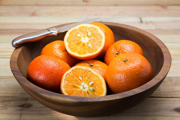 Fruta laranja na mesa de madeira com faca