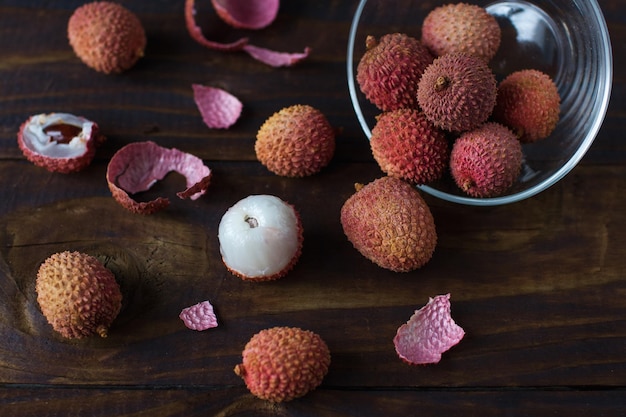 Fruta de lichi orgánica cruda sobre fondo de madera rústica oscura