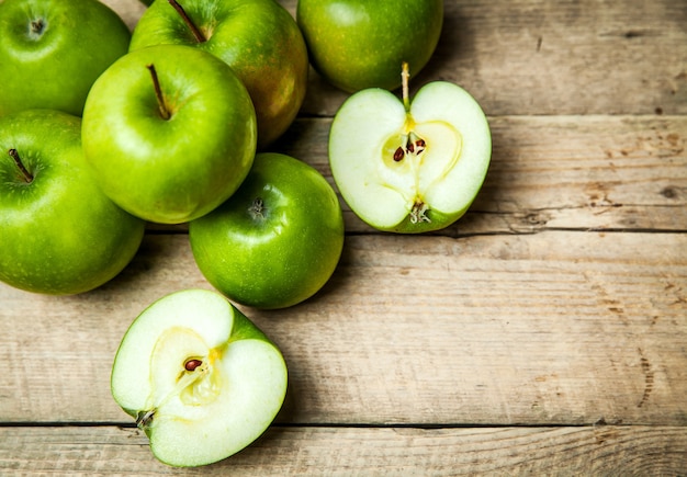 Fruta. Maçãs verdes maduras em madeira