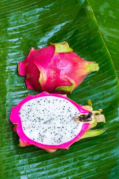 Fruta madura del dragón en una hoja verde mojada. Vitaminas, frutas, alimentos saludables.